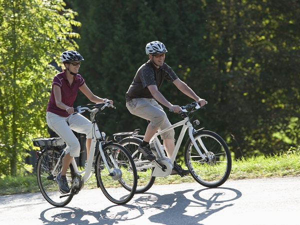 Ein Paar fährt mit den E-Bikes über einen Hügel