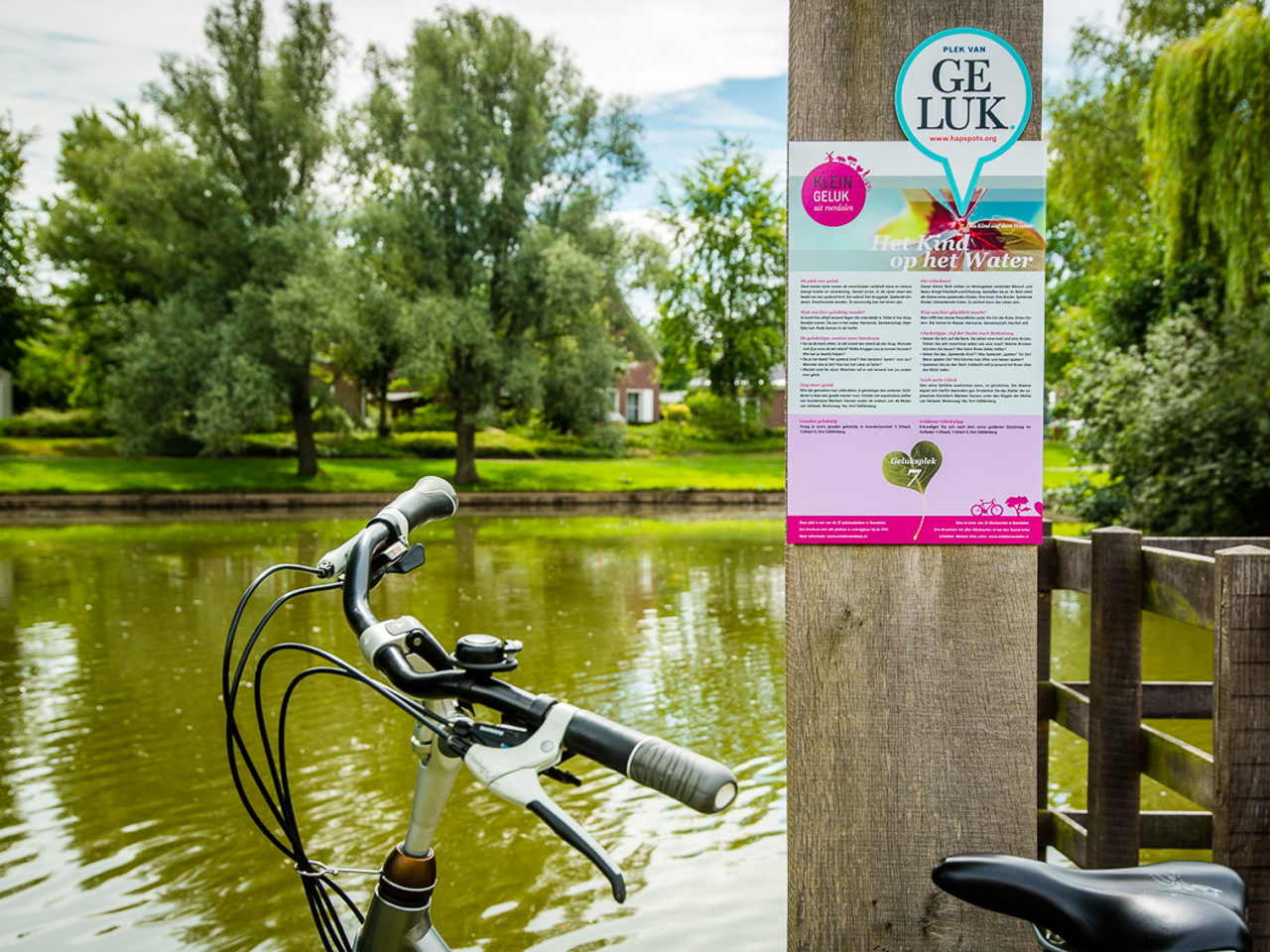 Een fiets staat geparkeerd tegen een informatiebord